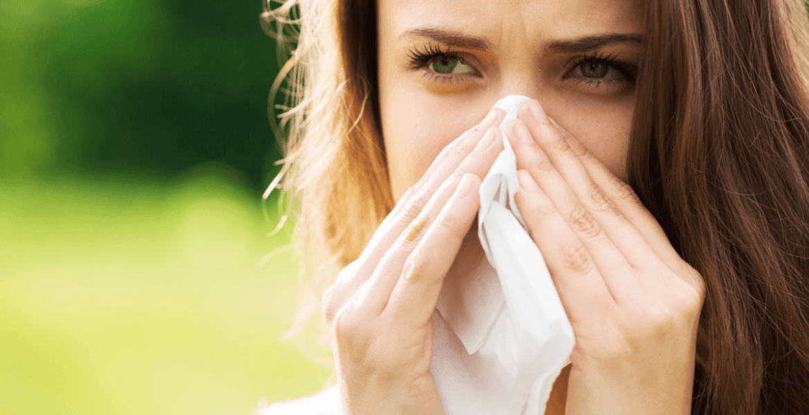 Person sneezing into tissue