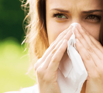 Person sneezing into tissue