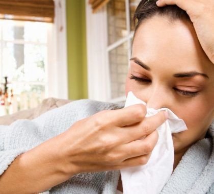 Woman with flu blowing her nose