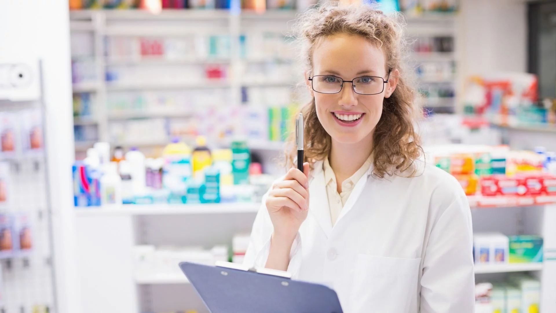 Smiling pharmacist with glasses and clipboard