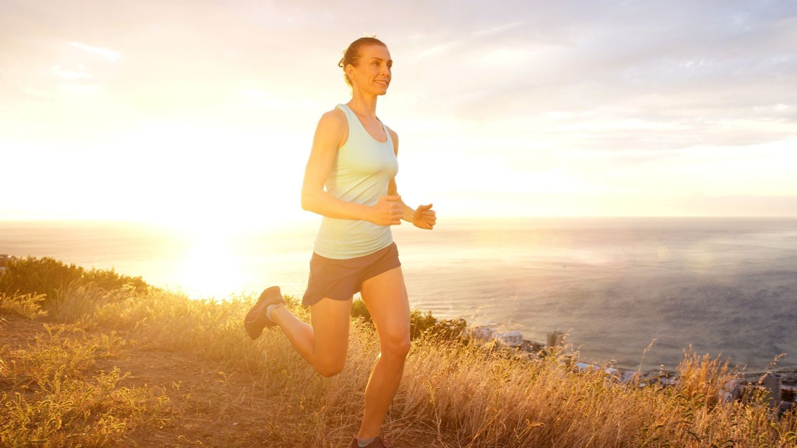 Person running on hill during sunset