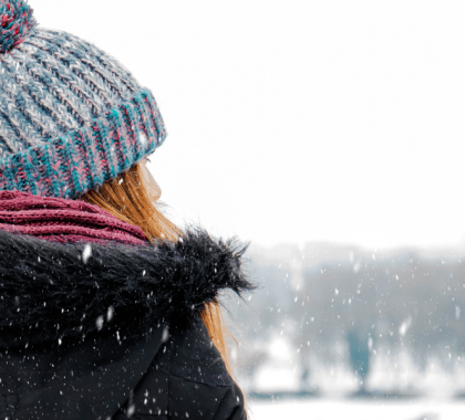 Person in winter gear staring at snow