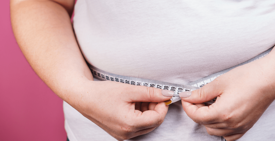 Person measuring stomach with measuring tape