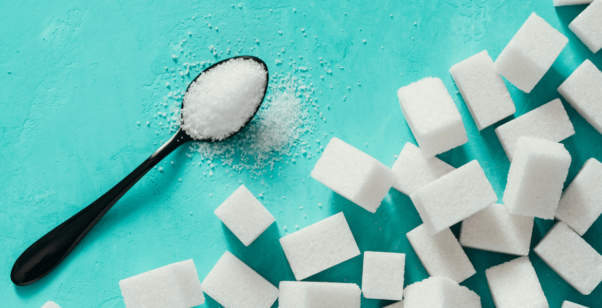 Spoon of sugar next to sugar cubes