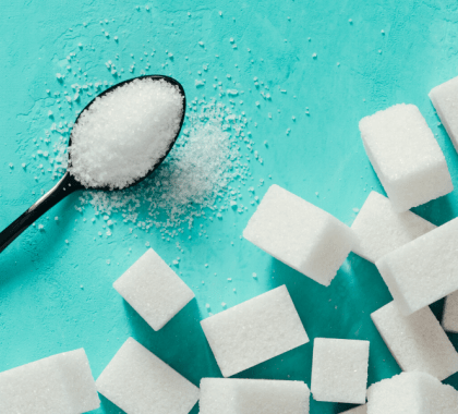 Spoon of sugar next to sugar cubes