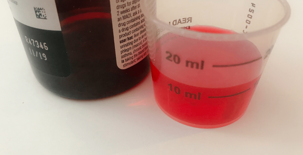 Red medicine in a measured beaker