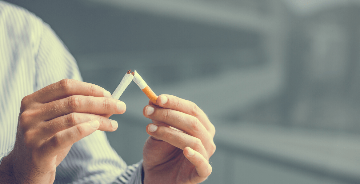 Someone breaking a cigarette in half