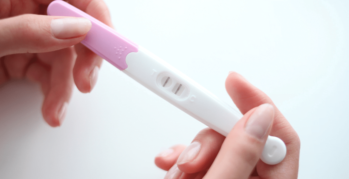 Woman holding a pregnancy test