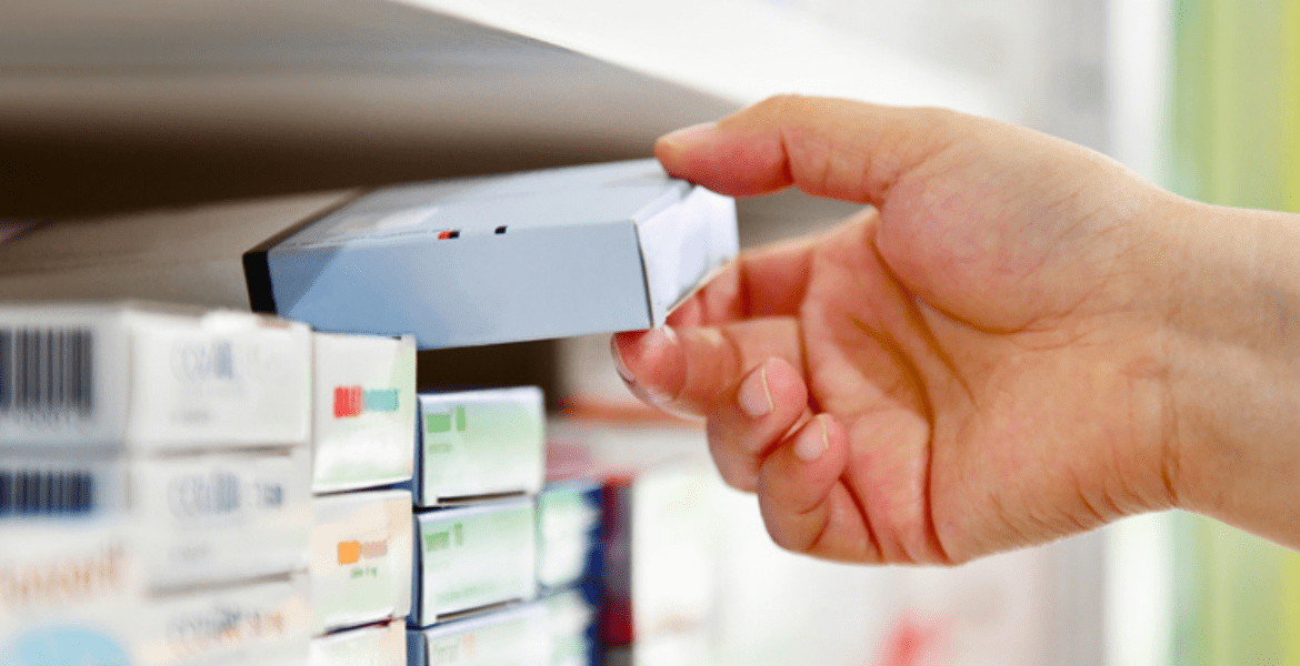 Hand placing box of medicine on shelf
