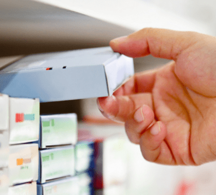 Hand placing box of medicine on shelf