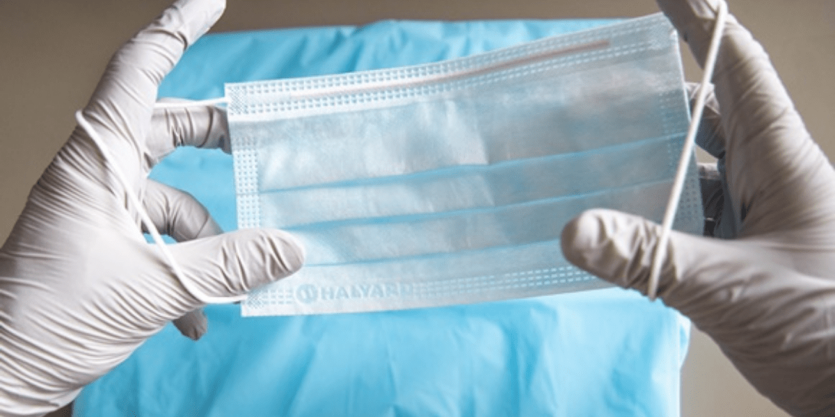 Person holding disposable face mask