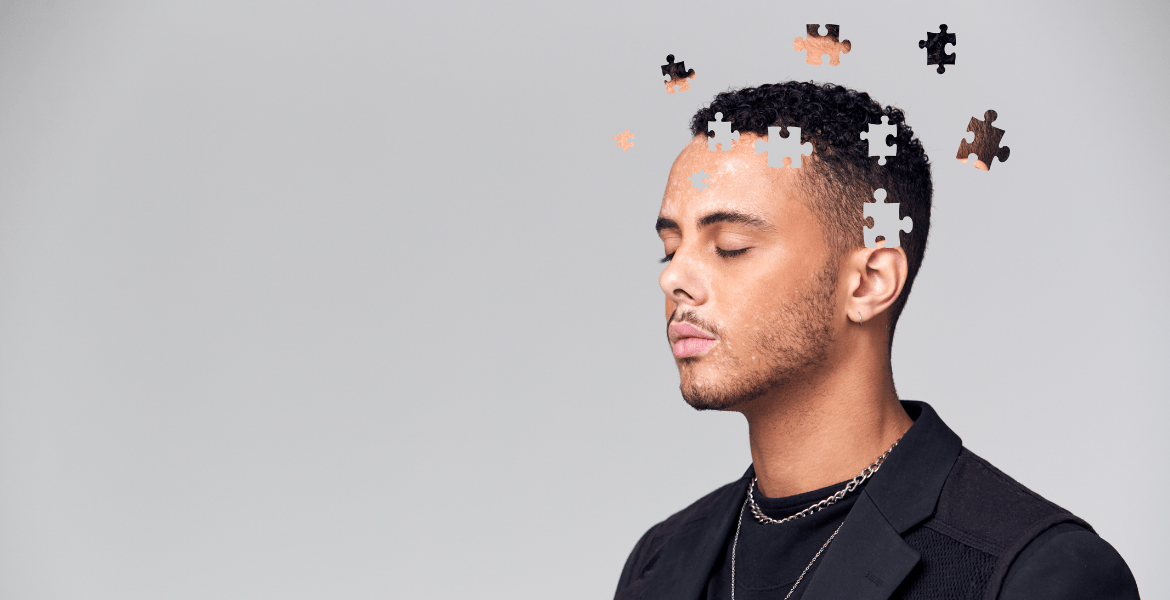 Man with closed eyes and puzzle pieces of his head floating away
