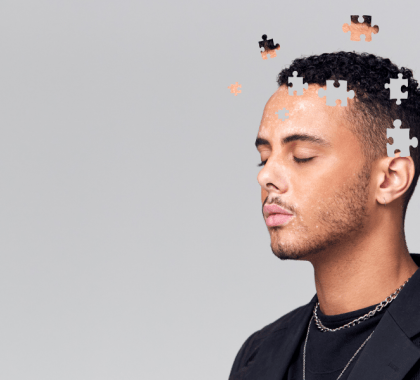 Man with closed eyes and puzzle pieces of his head floating away