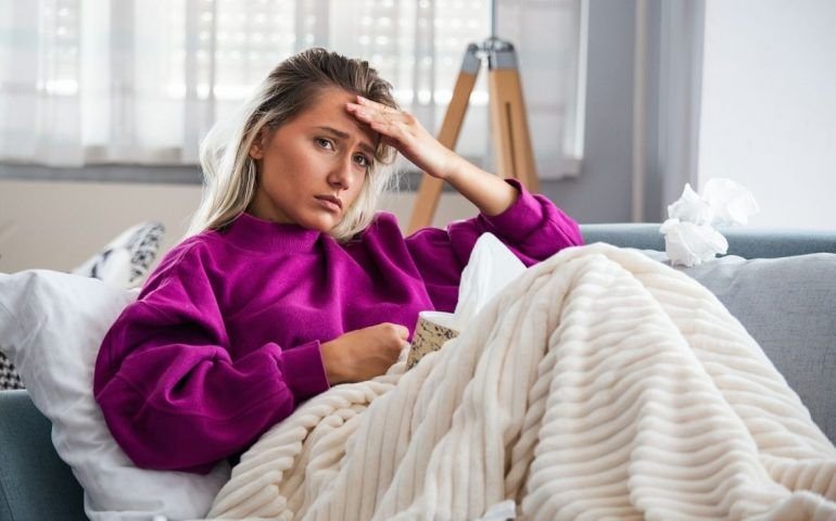 Sick woman in bed with headache