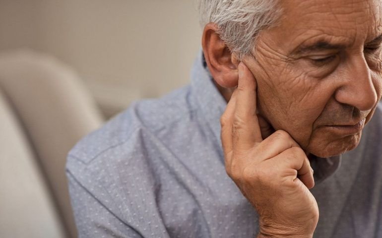 Old man pressing against ear