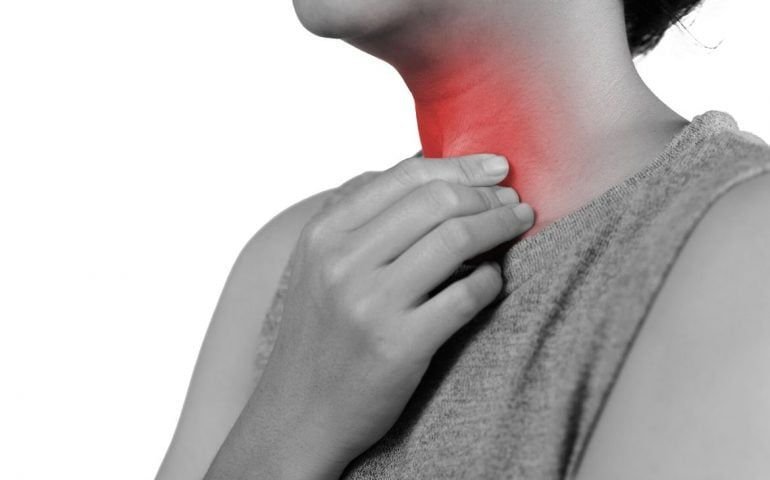 Person clutching glowing red throat