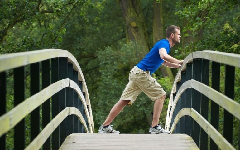 Person leaning on bridge outdoors