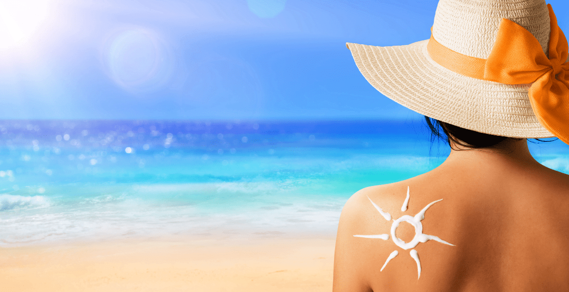 Woman with sun cream on shoulder on sunny beach