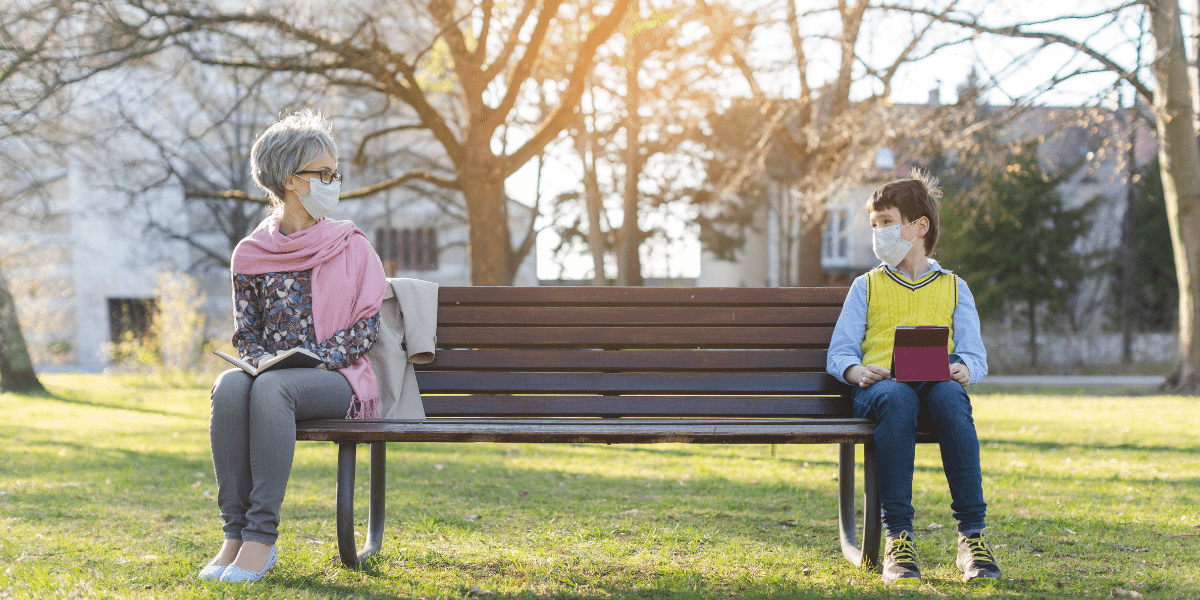 Old woman and child social distancing on bench