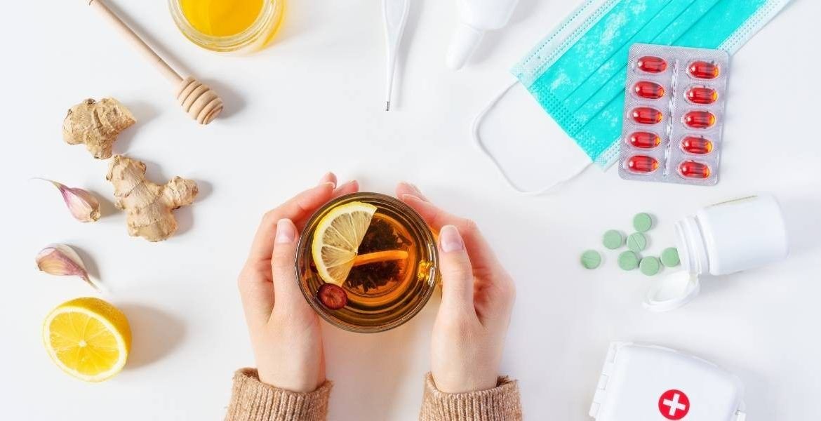 A flu remedy surrounded by tablets, a lemon and honey