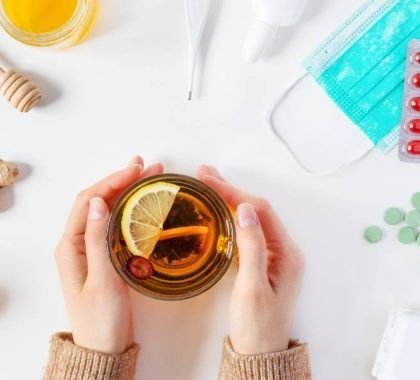 A flu remedy surrounded by tablets, a lemon and honey