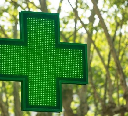 A green cross pharmacy logo