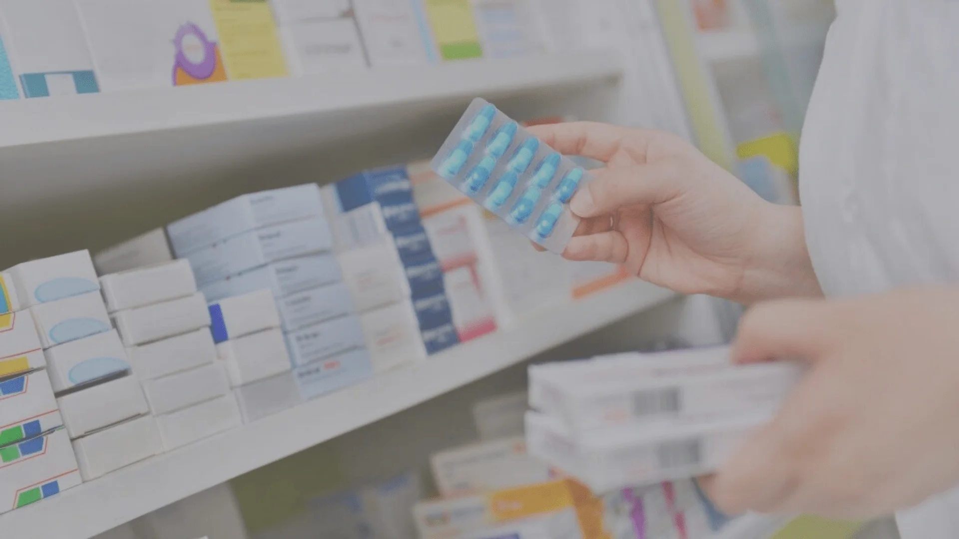 A nurse selecting medication from a shelf