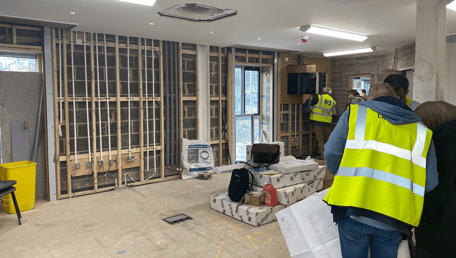 construction site with a worker in a green vest