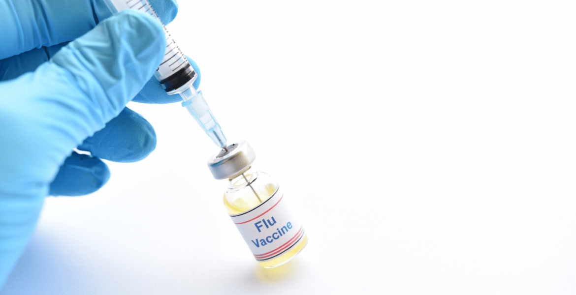 Syringe inserted into vial labelled 'Flu vaccine'